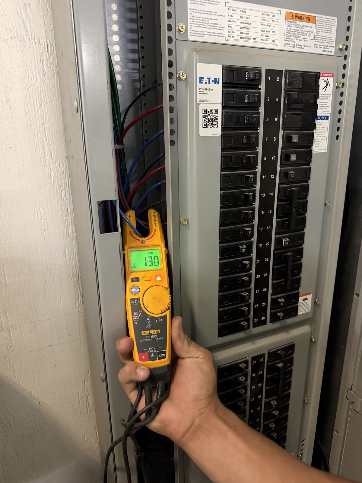 Keely Electric technician testing voltage at an electrical panel